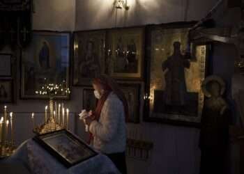 A woman attends a Christmas mass at an Orthodox Church in Bobrytsia, outskirts of Kyiv, Ukraine, Sunday, Dec. 25, 2022.
