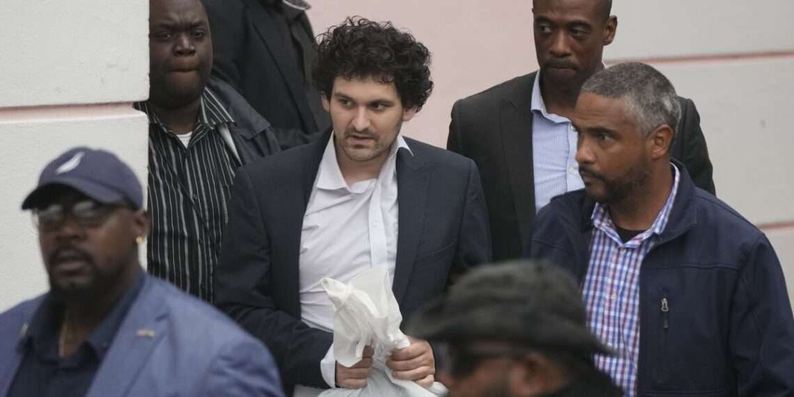 FTX founder Sam Bankman-Fried, center, is escorted from the Magistrate Court in Nassau, Bahamas, Wednesday, Dec. 21, 2022.