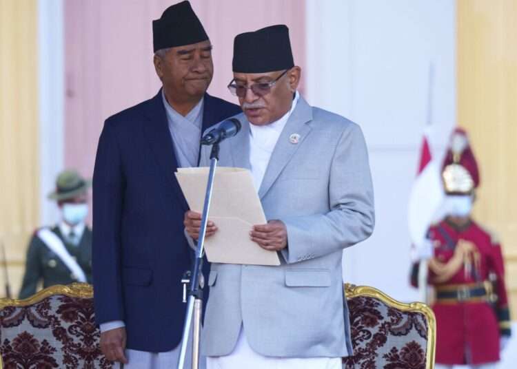 Nepal’s former prime minister Sher Bahadur Deuba, left, reacts as newly elected prime minister Pushpa Kamal Dahal, right, takes oath during a ceremony at the President House in Kathmandu, Nepal, Monday, Dec. 26, 2022.
