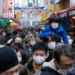 People wearing face masks flock to a shopping street famous for a year-end shopping before New Year holidays in Tokyo, Friday, Dec. 30, 2022.
