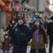 Visitors wearing face masks tour a pedestrian shopping street at Qianmen walking street in Beijing, Tuesday, Jan. 3, 2023.
