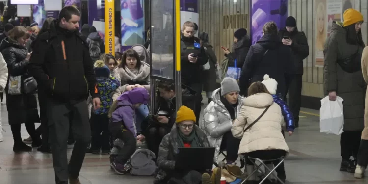 People gather in a subway station being used as a bomb shelter during a rocket attack in Kyiv, Ukraine, Thursday, Jan. 26, 2023.