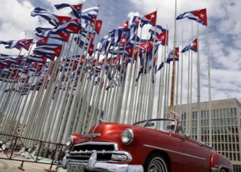 A classic American convertible car passes beside the United States embassy as Cuban flags fly at the Anti-Imperialist Tribune, a massive stage on the Malecon seaside promenade in Havana, Cuba, July 26, 2015.