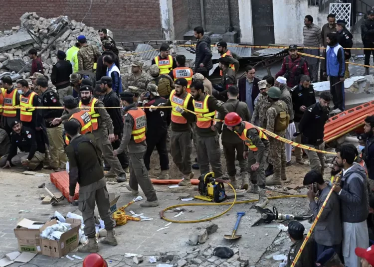 Security officials and rescue workers gather at the site of suicide bombing, in Peshawar, Pakistan, Monday, Jan. 30, 2023