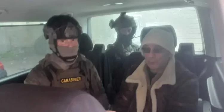 In this Italian Carabinieri handout photo made available on Monday, Jan. 16, 2023, top Mafia boss Matteo Messina Denaro, right, is seen in a car with Italian Carabinieri officers soon after his arrest at a private clinic in Palermo, Sicily.