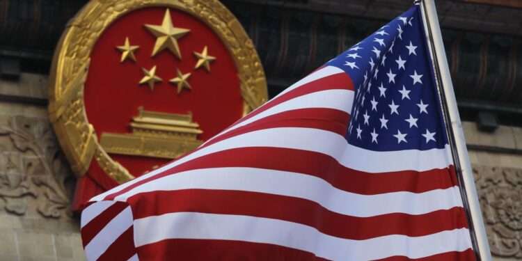 An American flag is flown next to the Chinese national emblem during a welcome ceremony at the Great Hall of the People in Beijing, Nov. 9, 2017