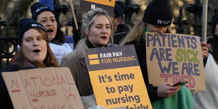 Nurses of the nearby St. Thomas' Hospital stand on the picket line, in London, Monday, Feb. 6, 2023