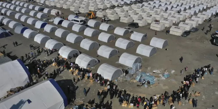 People who lost their houses in the devastating earthquake, lineup to receive aid supplies at a makeshift camp, in Iskenderun city, southern Turkey