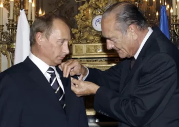 French President Jacques Chirac, right, hands over a rosette of the Legion of Honor to his visiting Russian counterpart Vladimir Putin during their meeting at the Elysee Palace in Paris, Friday Sept. 22, 2006.