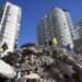 Emergency teams search for people in the rubble of a destroyed building in Adana, southern Turkey, Tuesday, Feb. 7, 2023