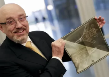 Ukraine's Defense Minister, Oleksiy Reznikov shows a handkerchief with a F-35 fighter jet when heading to a meeting with United States Secretary of Defense Lloyd Austin, on the sidelines of a NATO defense ministers meeting at NATO headquarters in Brussels, Tuesday, Feb. 14, 2023.