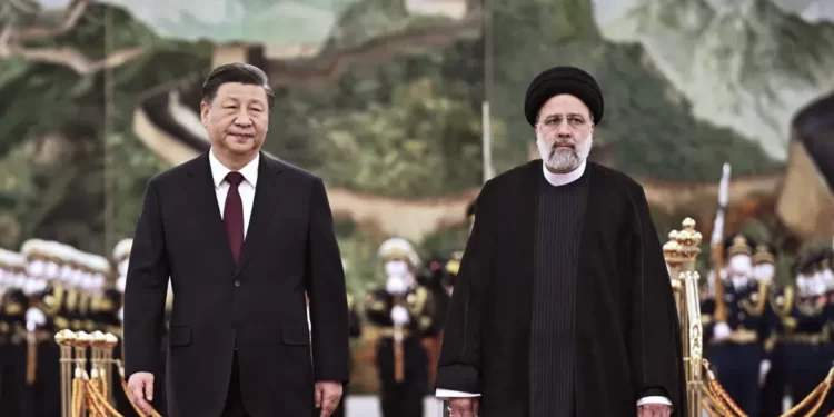 visiting Iranian President Ebrahim Raisi, right, walks with Chinese President Xi Jinping after reviewing an honor guard during a welcome ceremony at the Great Hall of the People in Beijing,