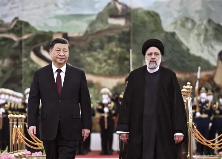visiting Iranian President Ebrahim Raisi, right, walks with Chinese President Xi Jinping after reviewing an honor guard during a welcome ceremony at the Great Hall of the People in Beijing,