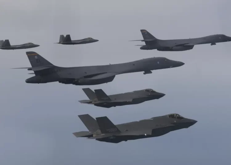 In this photo provided by South Korean Defense Ministry, U.S. Air Force B-1B bombers, center, F-22 fighter jets and South Korean Air Force F-35 fighter jets, bottom, fly over South Korea Peninsula during a joint air drill in South Korea, on Jan. 1, 2023
