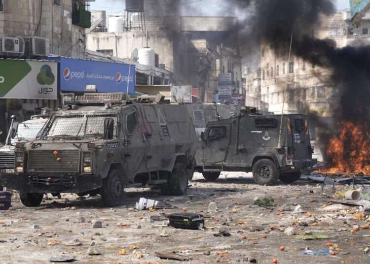 Smoke from fires fills the air as Palestinians clash with Israeli forces in the West Bank city of Nablus