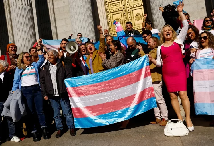 Spain's Minister for Equality Irene Montero, centre, celebrates the final approval of a law that will make it easier for people to self-identify as transgender, with LGBTQ activists outside Spain's Parliament in Madrid, Spain