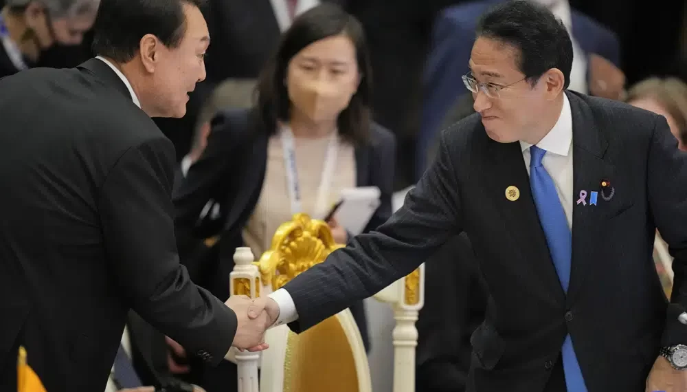 Japan's Prime Minister Fumio Kishida, right, shakes hands with South Korea's President Yoon Suk Yeol during the ASEAN - East Asia Summit in Phnom Penh, Cambodia, on Nov. 13, 2022