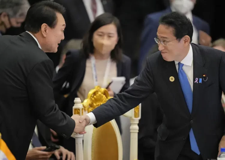 Japan's Prime Minister Fumio Kishida, right, shakes hands with South Korea's President Yoon Suk Yeol during the ASEAN - East Asia Summit in Phnom Penh, Cambodia, on Nov. 13, 2022