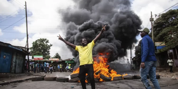 Kenya Opposition Holds Fresh Protests Despite Government Warning 1 rotesters react next to a burning barricade during a mass rally called by the opposition leader Raila Odinga over the high cost of living, in Kibera Slum, Nairobi, Kenya, Thursday, March 30, 2023.