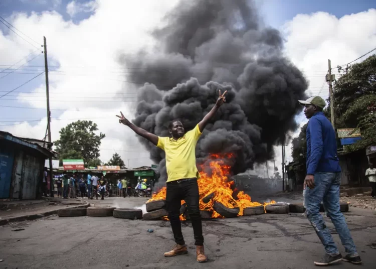 Kenya Opposition Holds Fresh Protests Despite Government Warning 1 rotesters react next to a burning barricade during a mass rally called by the opposition leader Raila Odinga over the high cost of living, in Kibera Slum, Nairobi, Kenya, Thursday, March 30, 2023.
