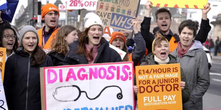 Junior doctors hold placards as they stand at a picket line outside St Thomas' Hospital in Westminster in London, Monday, March 13, 2023.