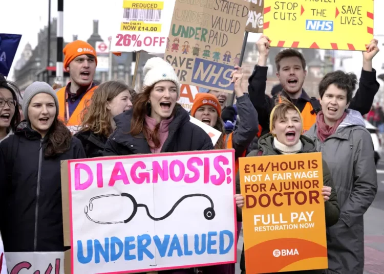 Junior doctors hold placards as they stand at a picket line outside St Thomas' Hospital in Westminster in London, Monday, March 13, 2023.