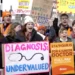 Junior doctors hold placards as they stand at a picket line outside St Thomas' Hospital in Westminster in London, Monday, March 13, 2023.