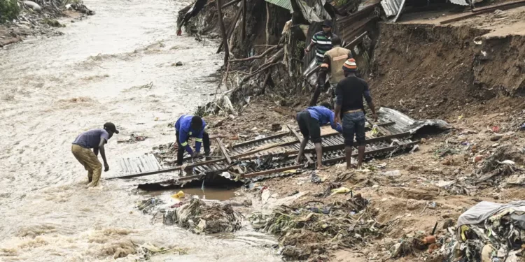 Men salvage parts from their destroyed home, following heavy rains caused by Cyclone Freddy in Blantyre, southern Malawi, Wednesday, March 15, 2023.