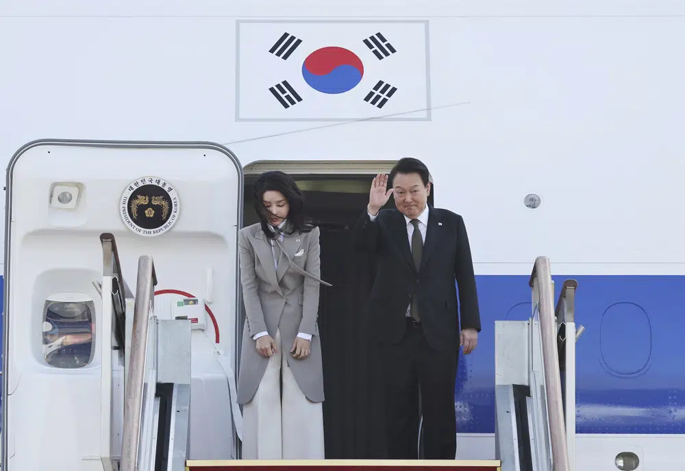 South Korean President Yoon Suk Yeol right waves as his wife Kim Keon Hee bows before departing for Japan at the Seoul military airport in Seongnam South Korea
