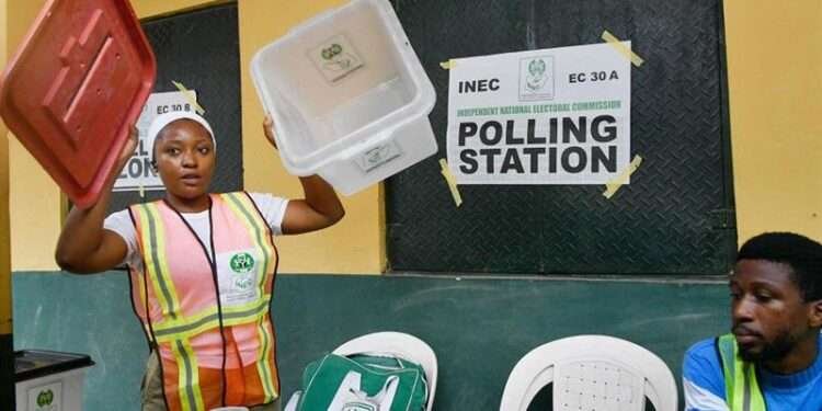 An electoral official displays an empty ballot box to party agents before voting begins at a polling station for a gubernatorial and House of Assembly candidate during local elections, in Lagos, on March 18, 2023.