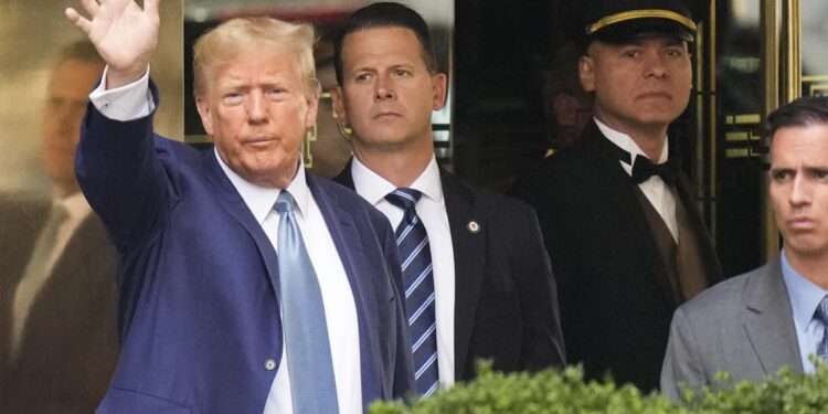 Former President Donald Trump, left, gestures as he leaves Trump Tower in New York, Thursday, April 13, 2023.