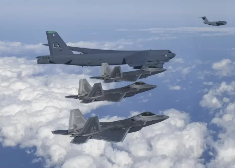 In this photo provided by South Korean Defense Ministry, a U.S. B-52 bomber, C-17, and U.S. Air Force F-22 fighter jets fly over the Korean Peninsula during a joint air drill in South Korea on Dec. 20, 2022.