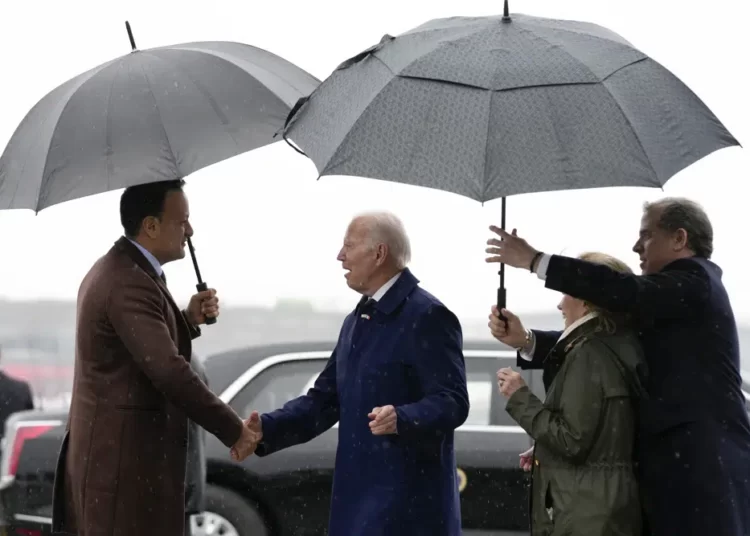 President Joe Biden shakes hands with Ireland's Taoiseach Leo Varadkar, left,as his son Hunter Biden, right, and his sister Valerie Biden Owens, second from right, hold an umbrella for him at Dublin International Airport in Dublin, Ireland, Wednesday, April 12, 2023.