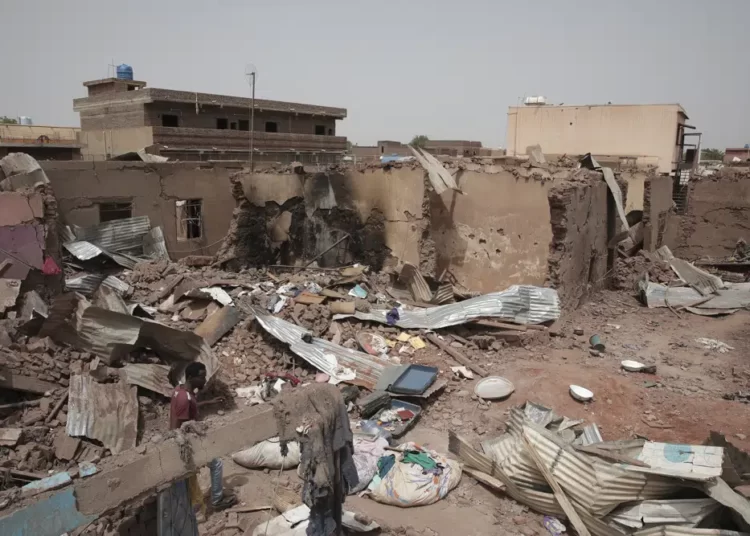 A man walks by a house hit in recent fighting in Khartoum, Sudan, Tuesday, April 25, 2023.