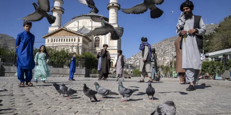 Afghan people walk pass the Shah-Do Shamshira Mosque during the first day of Eid al-Fitr in Kabul, Afghanistan, Friday, April 21, 2023.