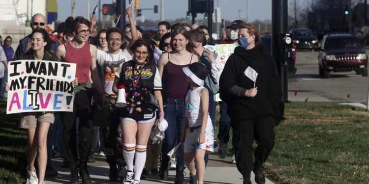 More than 100 people, many of them transgender youth, march around the Kansas Statehouse on the annual Transgender Day of Visibility, Friday, March 31, 2023, in Topeka, Kansas.
