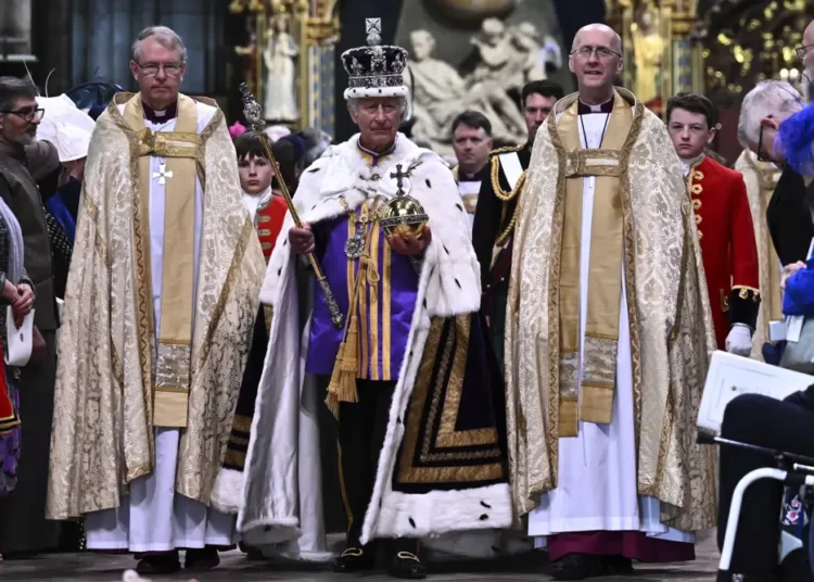 Britain's King Charles III wearing the Imperial state Crown and carrying the Sovereign's Orb and Sceptre leaves Westminster Abbey after coronation in central London Saturday, May 6, 2023.
