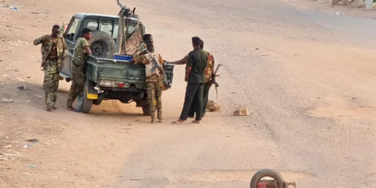 Sudanese army soldiers on a road blocked with bricks in Khartoum.