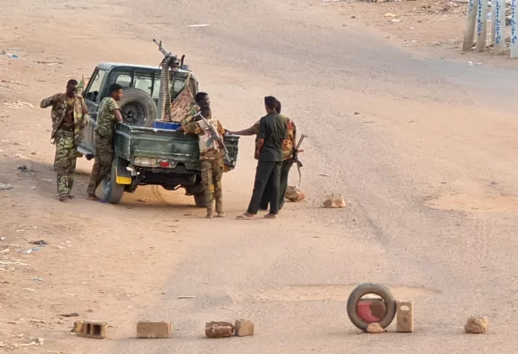 Sudanese army soldiers on a road blocked with bricks in Khartoum.