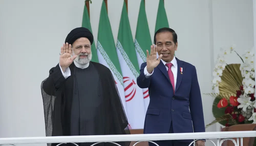 Iran's President Ebrahim Raisi, left, and Indonesian President Joko Widodo, right, wave to journalists during their meeting at the Presidential Palace in Bogor, West Java, Indonesia, Tuesday, May 23, 2023.