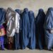 Afghan women wait to receive food rations distributed by a humanitarian aid group, in Kabul, Afghanistan, Tuesday, May 23, 2023.