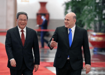 Russian Prime Minister Mikhail Mishustin, right, and Chinese Premier Li Qiang, left, arrive for a meeting at the Great Hall of the People in Beijing.