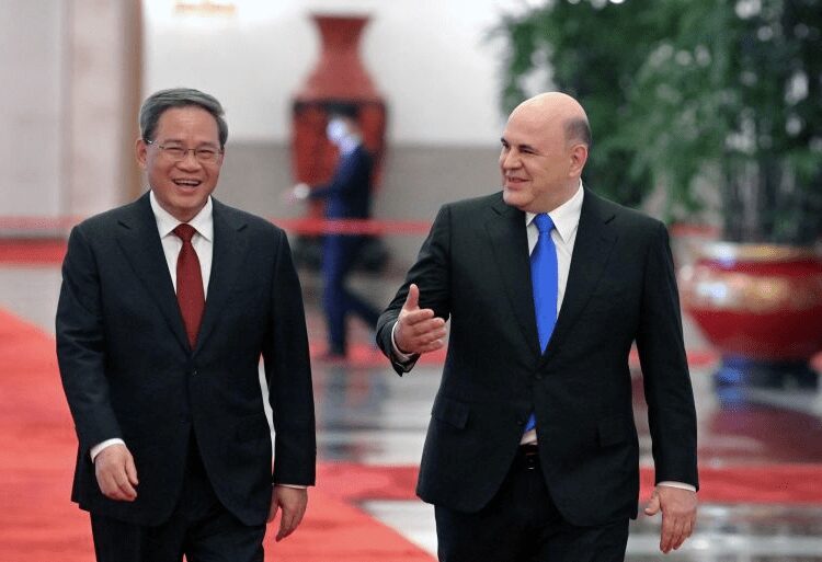 Russian Prime Minister Mikhail Mishustin, right, and Chinese Premier Li Qiang, left, arrive for a meeting at the Great Hall of the People in Beijing.