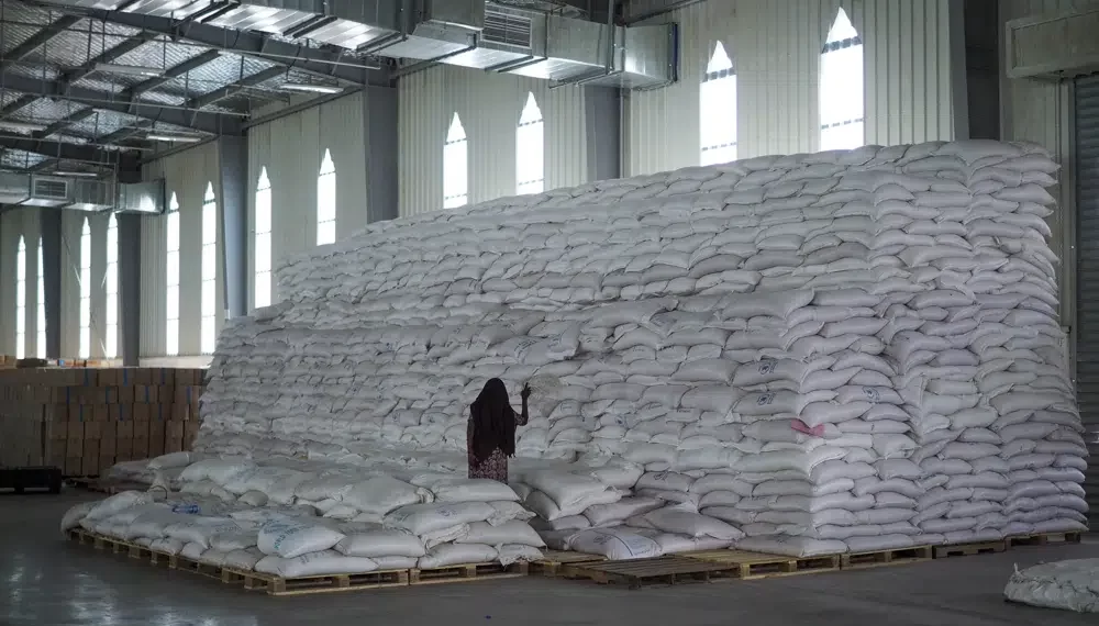 A worker walks next to a pile of sacks of food earmarked for the Tigray and Afar regions in a warehouse of the World Food Programme (WFP) in Semera, the regional capital for the Afar region, in Ethiopia.
