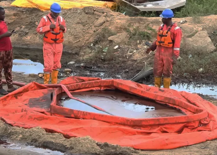 Shell Nigeria Discover An Oil Spillage From Their Oil Farm 1 In this grab taken from video, workers stand by a container to collect oil spill waste, in Ogoniland, Nigeria.