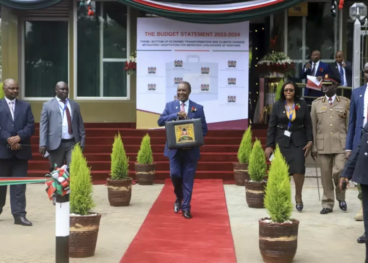 Pro Government Supporters Angry Over New Taxes 1 Kenya's Minister of Finance Njuguna Ndung'u holds a briefcase containing the government budget for upcoming fiscal year, at the Treasury headquarters in downtown Nairobi, Kenya.
