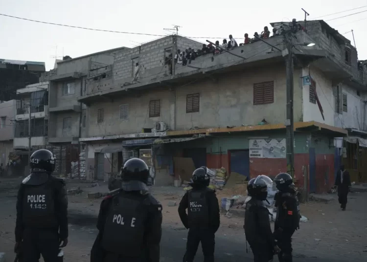Police in riot gear stand guard during clashes with demonstrators in Dakar, Senegal.