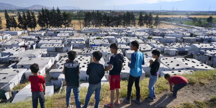 Syrian children stand on a hill above a refugee camp in the town of Bar Elias, in Lebanon's Bekaa Valley.