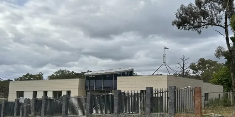 The Australian flag flies on Parliament House, seen behind an unoccupied building on the grounds of a proposed new Russian embassy near the Australian Parliament in Canberra.