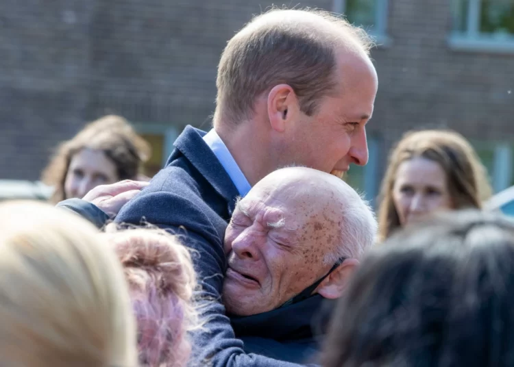 The Prince of Wales hugs an emotional well-wisher, named as William Burns, during a visit to Glasgow to hear about the challenges of homelessness.